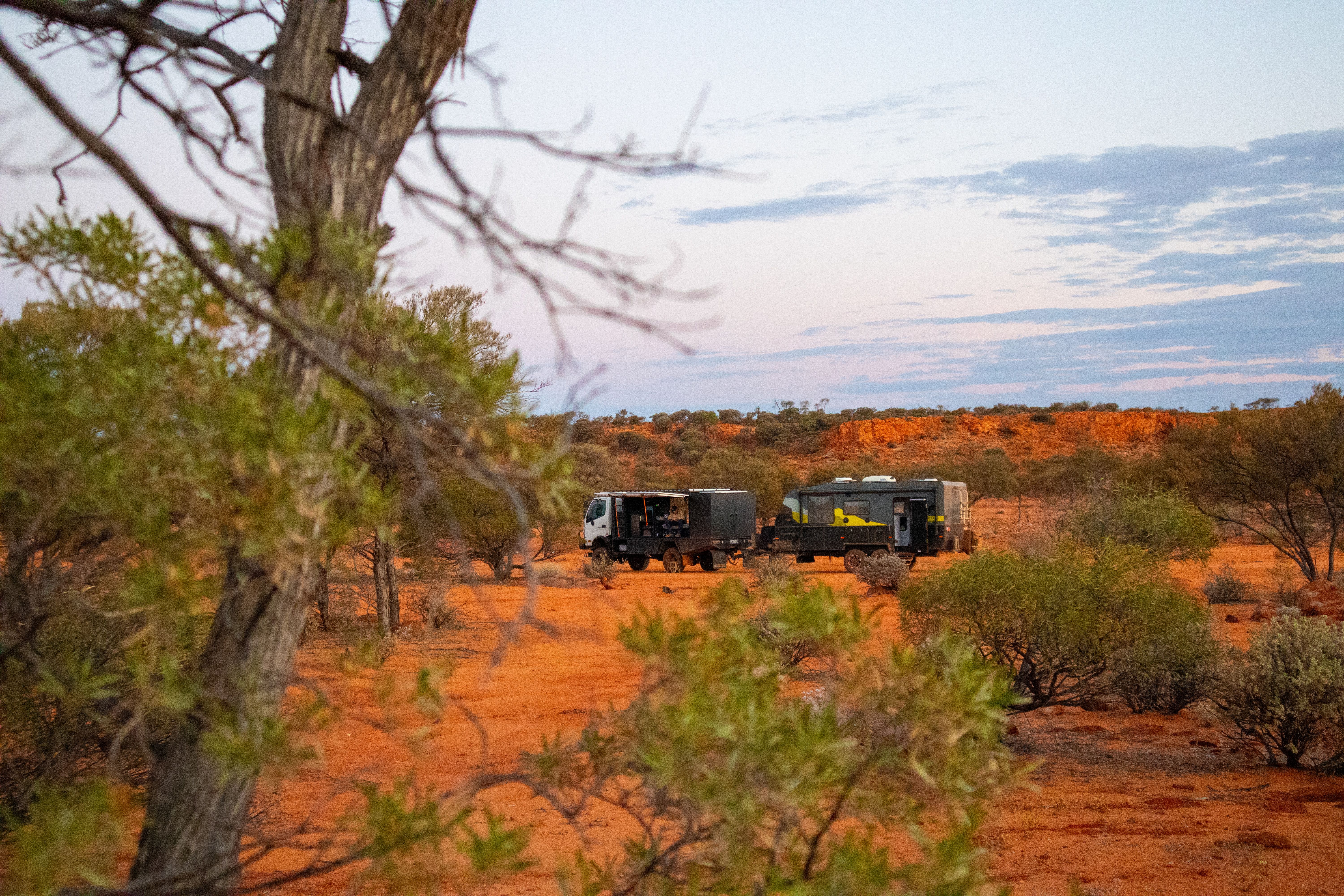 4x4 and caravan pictured in the outback with red dust 