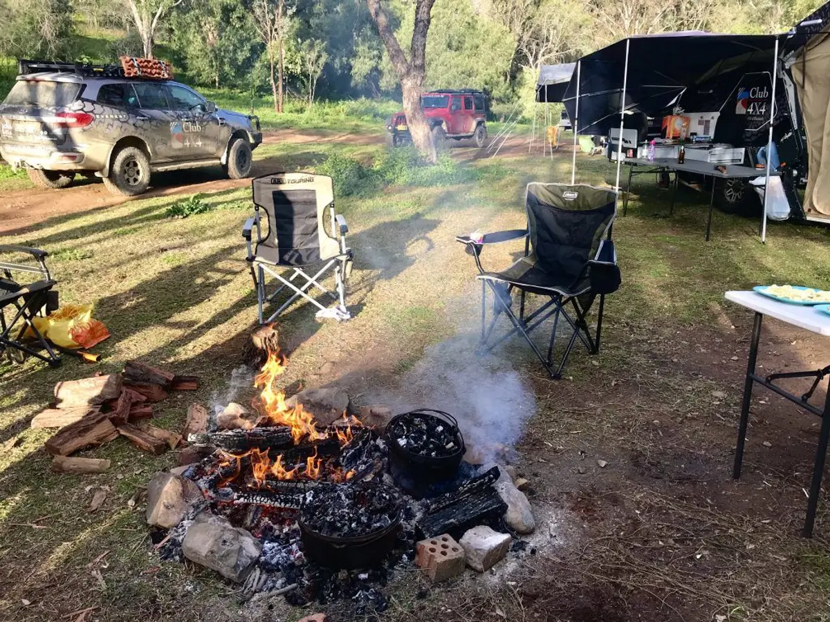 A group of people sitting around a fire Description automatically generated