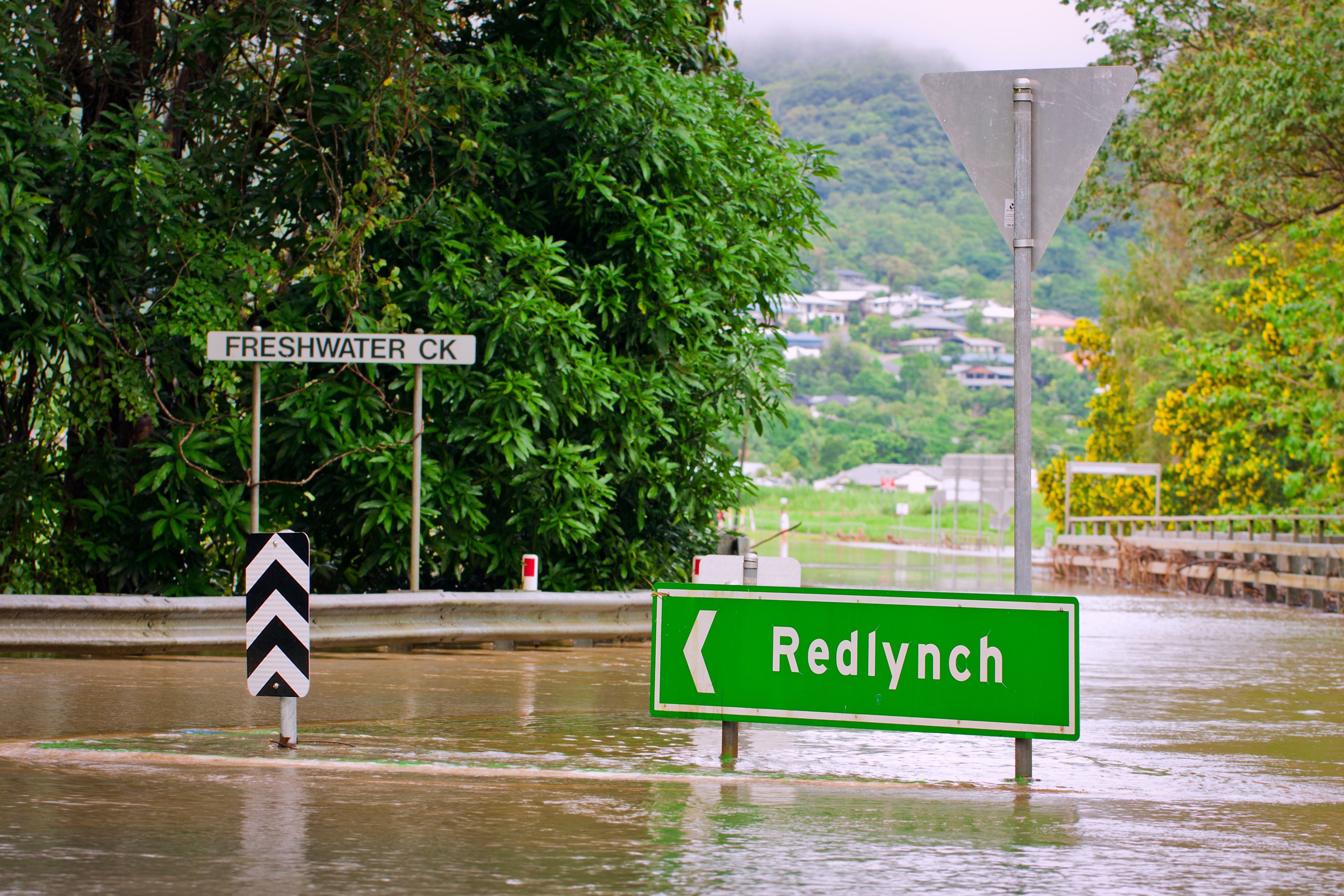green road sign in flood water