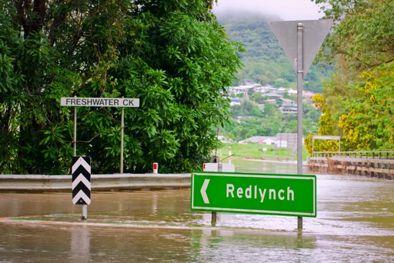 green road sign in flood water