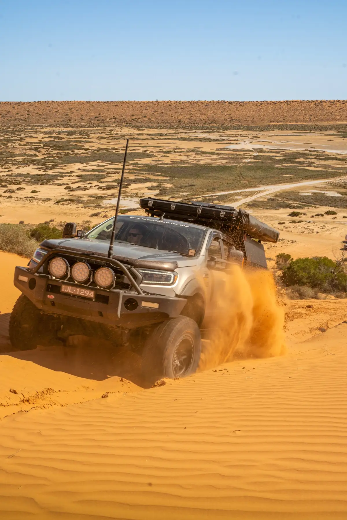 A 4X4 Ford Ranger ute driving up a sand dune in the Simpson Desert, Australia