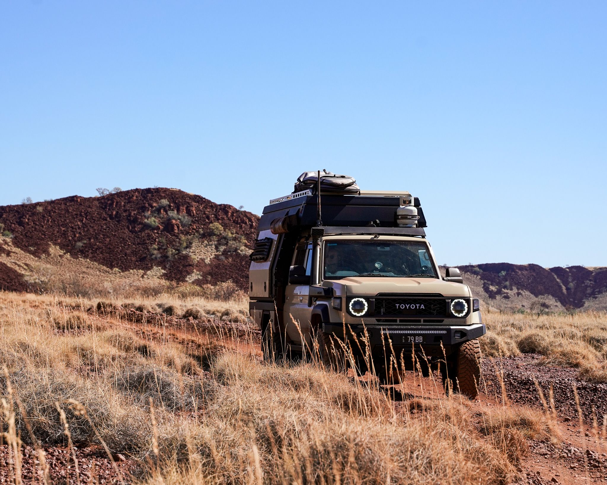 A Toyota LandCruiser 70 series driving though a grassy road