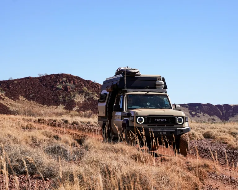A Toyota LandCruiser 70 series driving though a grassy road