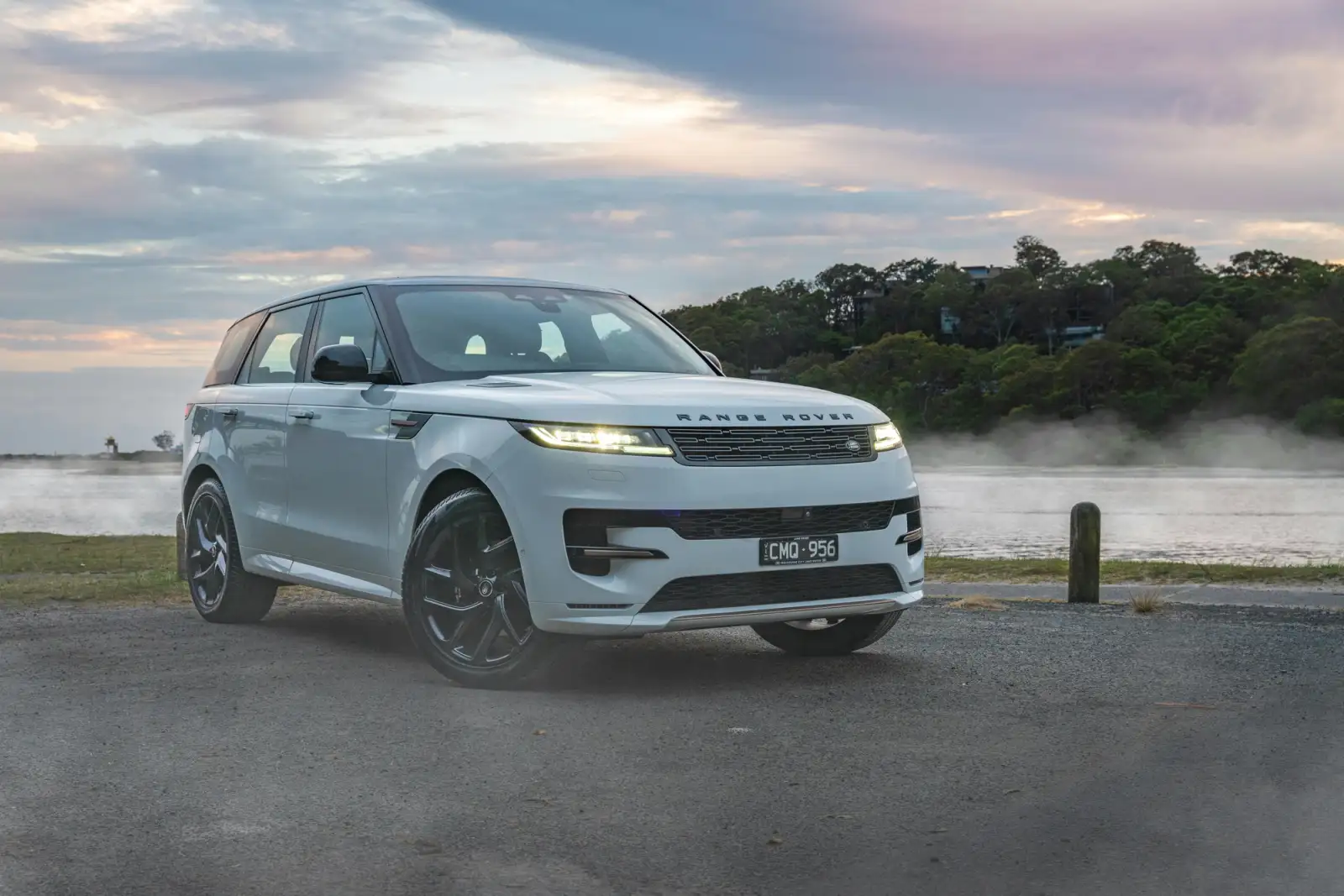 luxury white 4x4 in front of lake