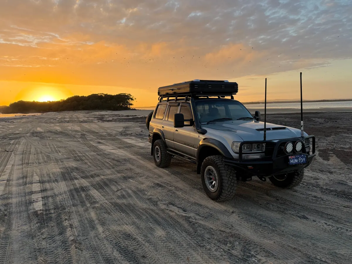 Toyota LandCruiser 80 Series on beach with sunset