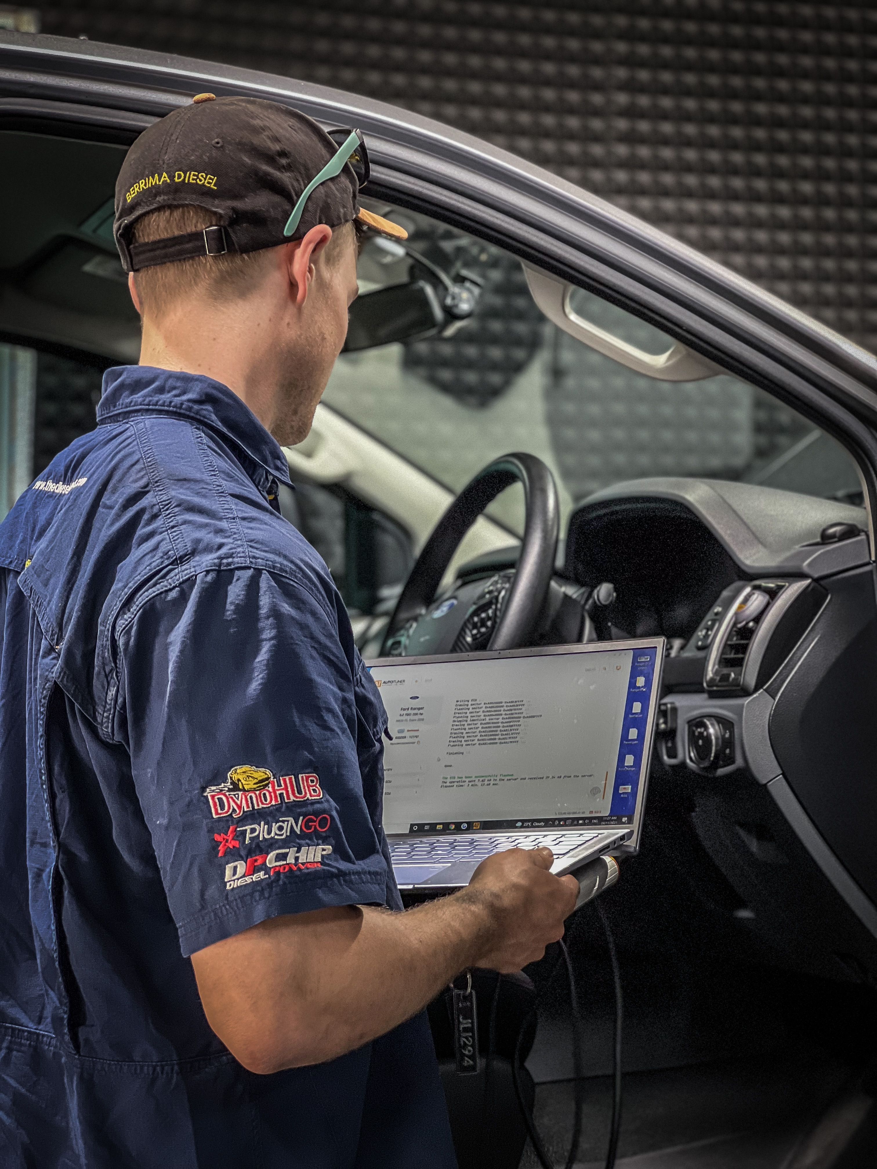 A man using a laptop to diagnose a 4X4
