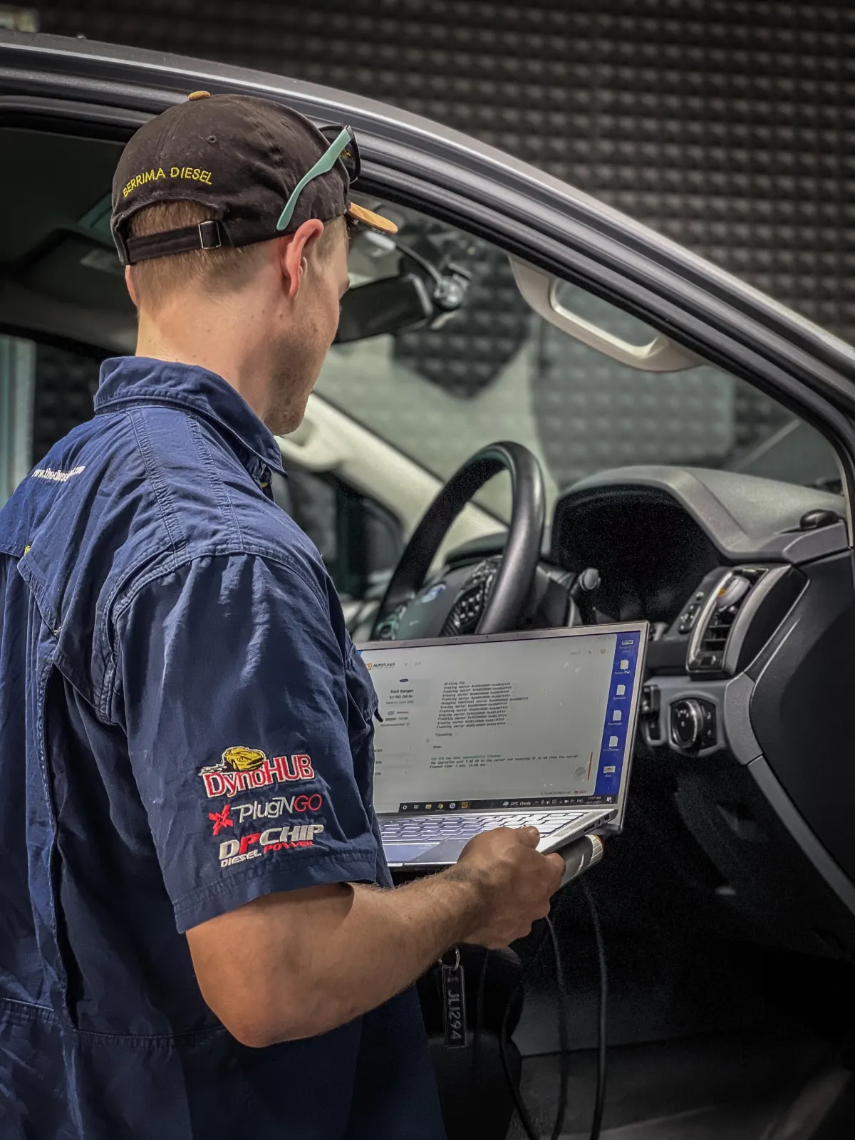 A man using a laptop to diagnose a 4X4