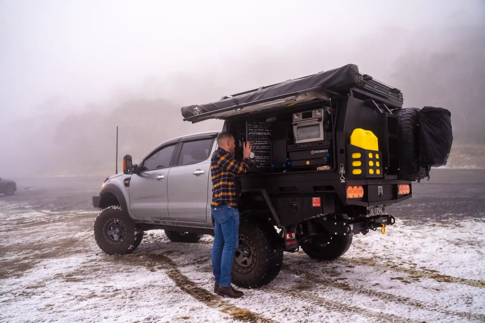grey 4x4 ford ranger and man in snowy environment