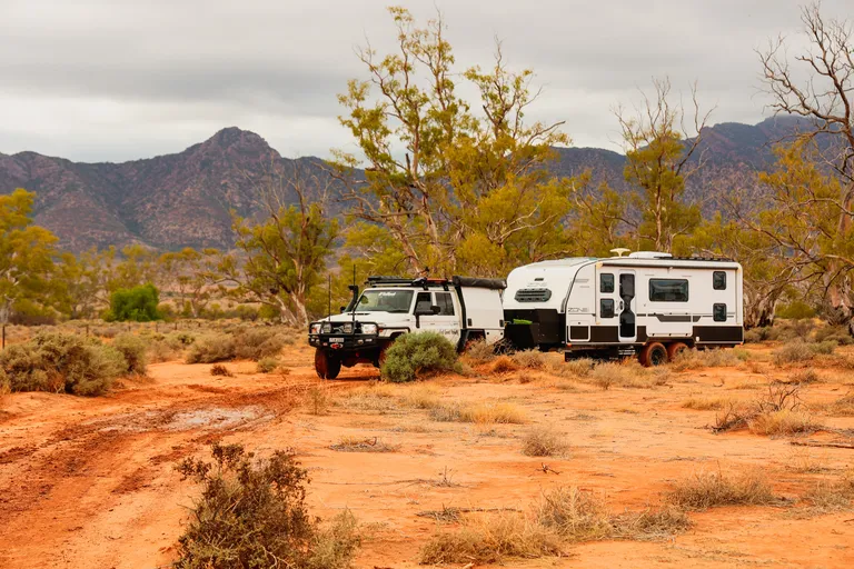 Toyota Landcruiser towing a caravan through arid landscape