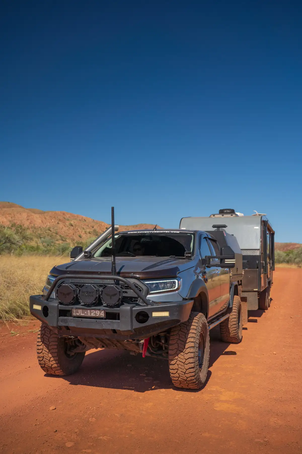 4x4 towing a caravan through red dirt