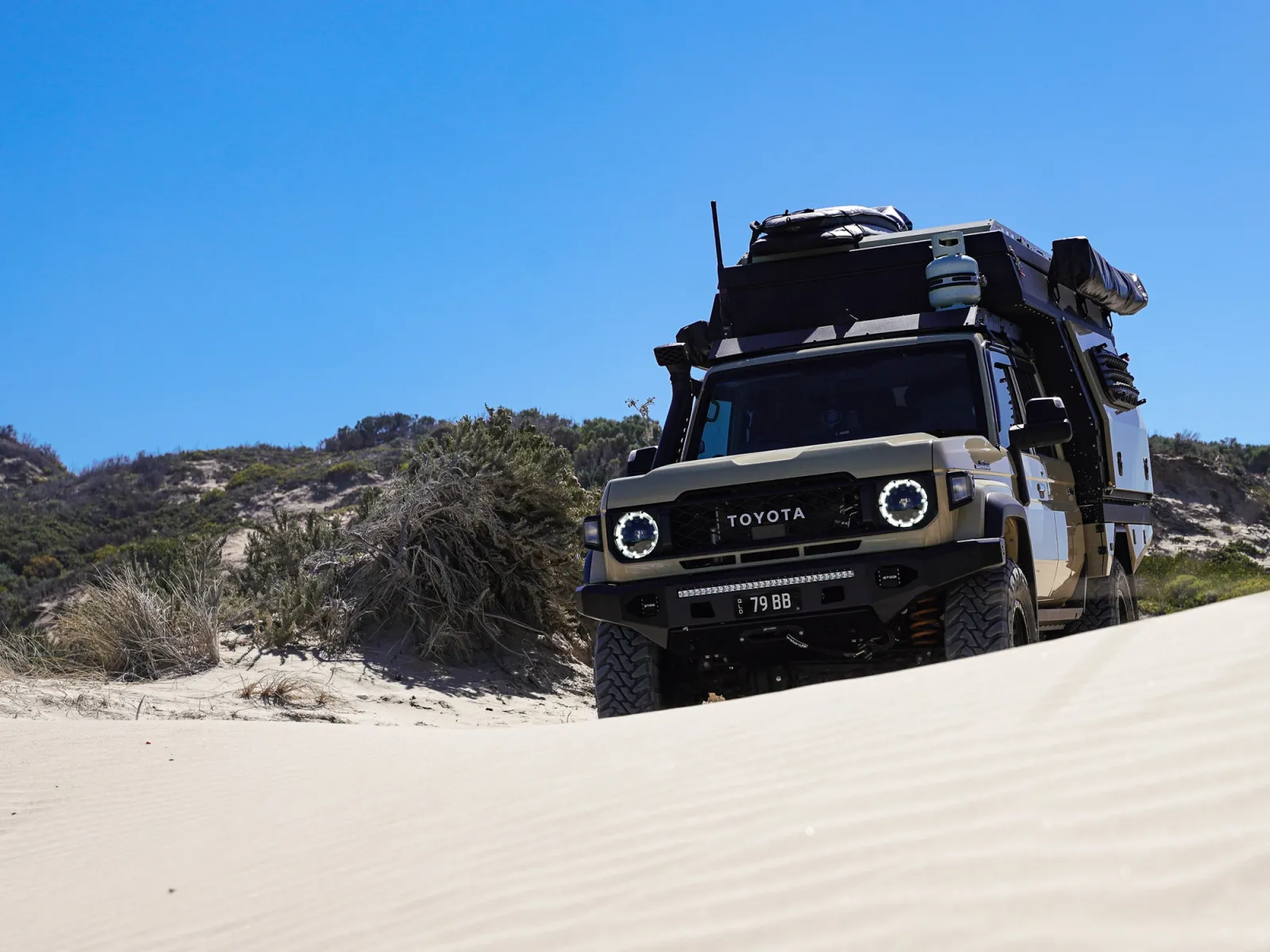 toyota landcruiser driving offroad through sand on beach
