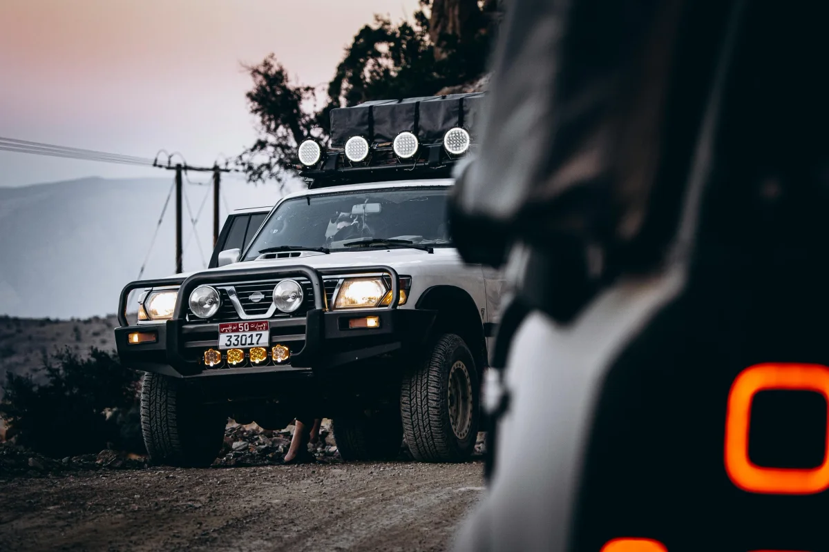 4WD with lights on and back of another car close up