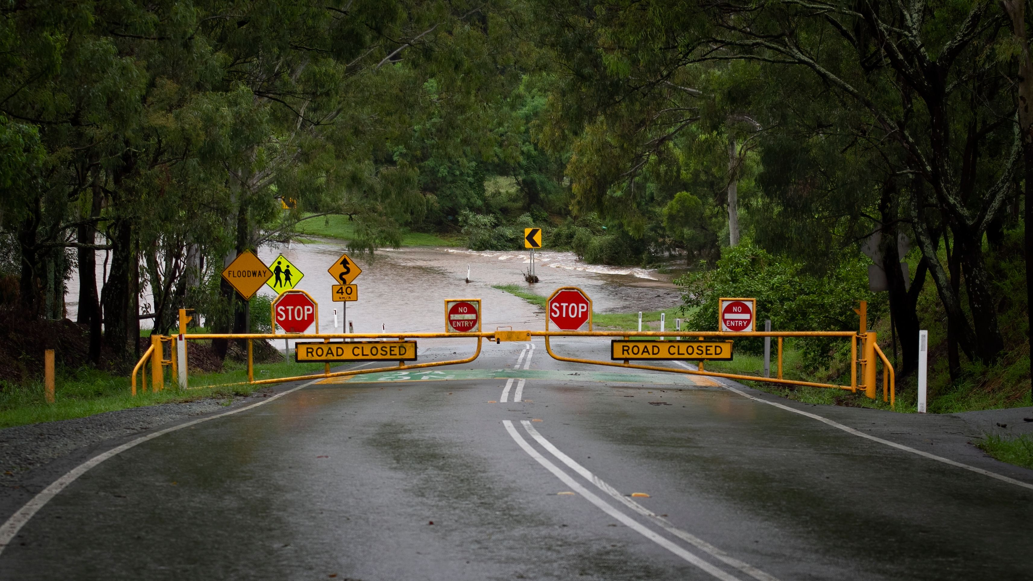 A flooded road with warning signs