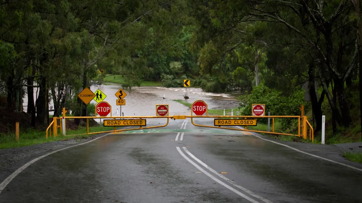 A flooded road with warning signs