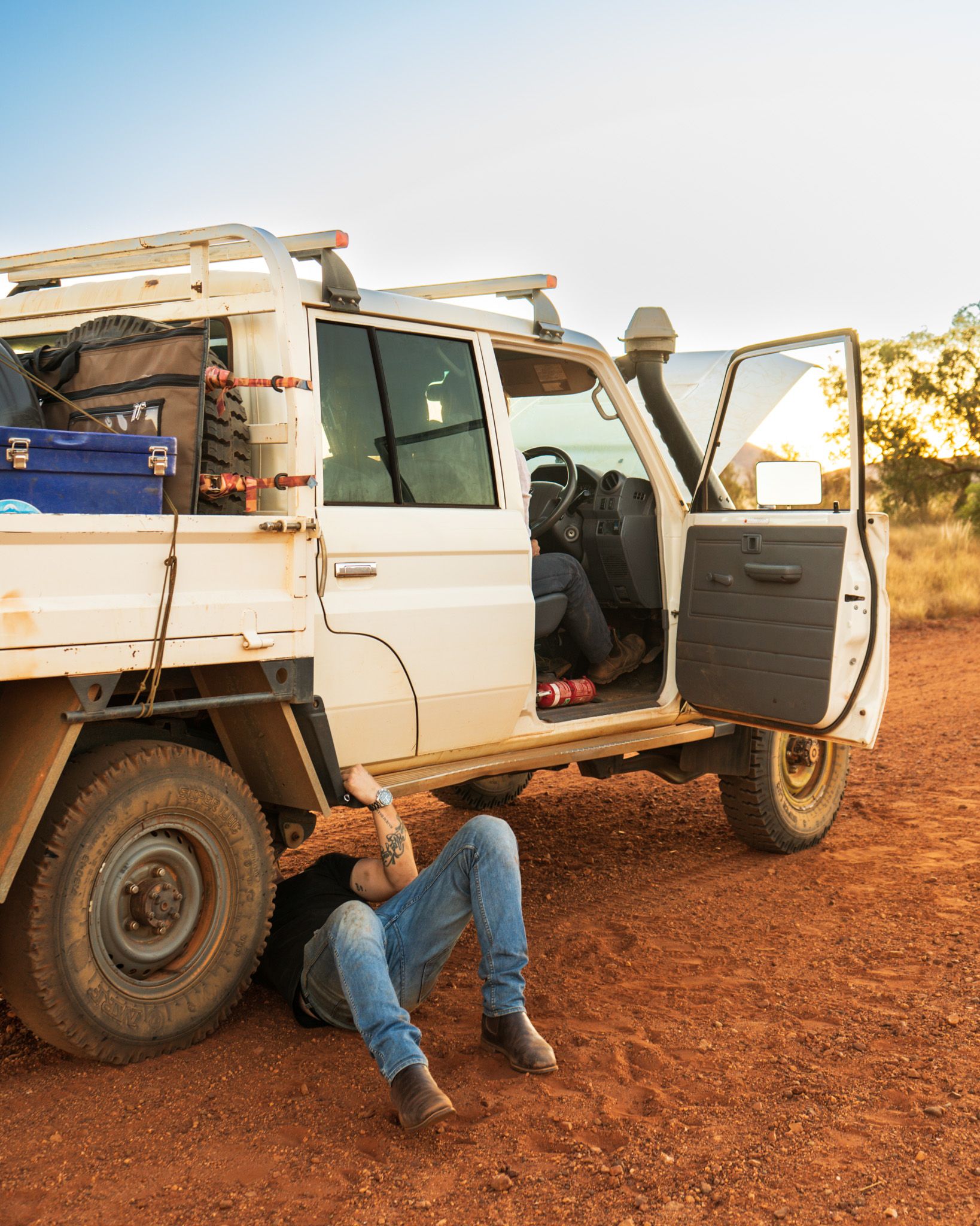 Josh Leonard under a Toyota ute in the Outback