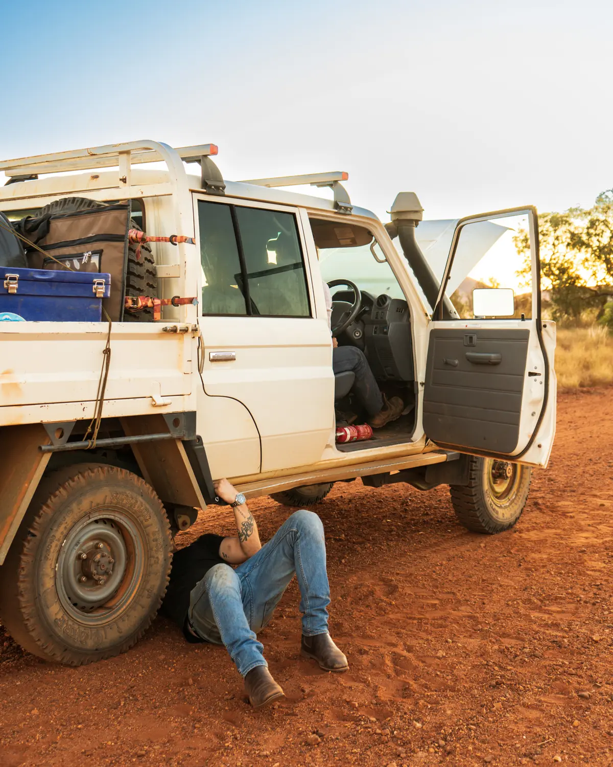 Josh Leonard under a Toyota ute in the Outback