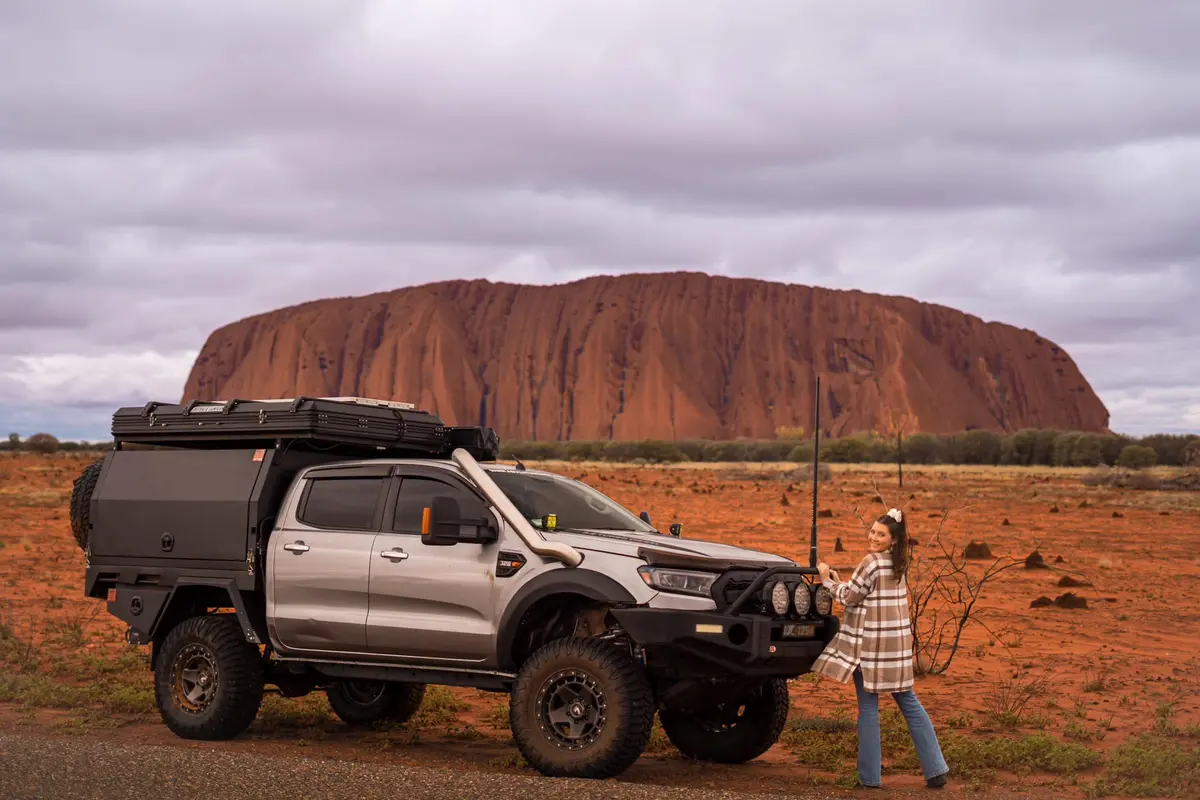 4X4 Ford Ranger and woman in front of Uluru in Australia's Red Centre