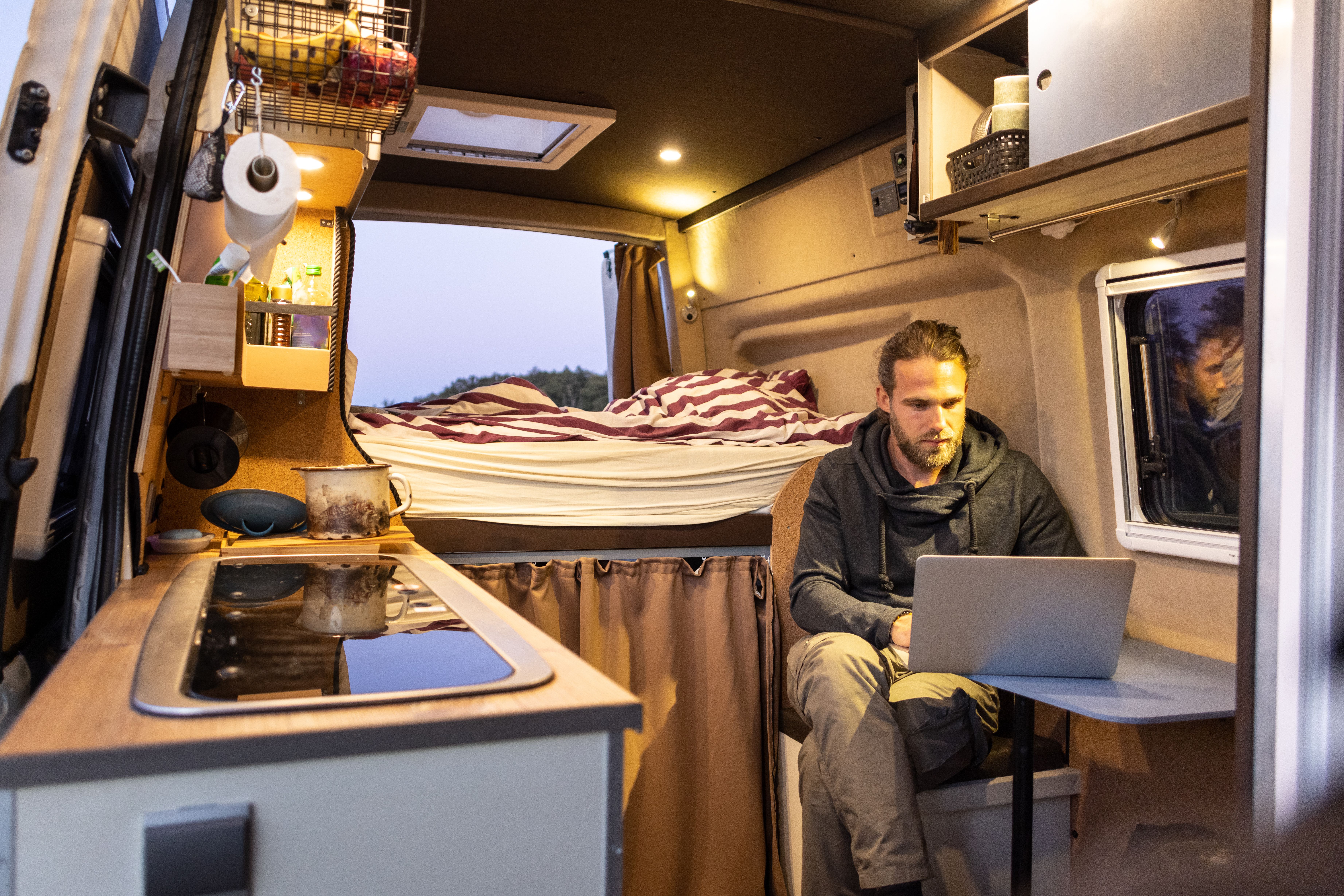 interior of an RV with man on a laptop