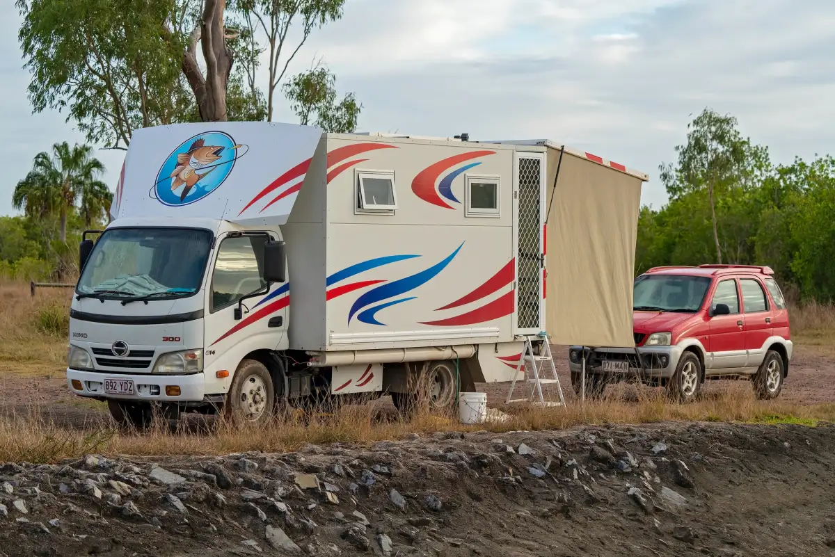 A motorhome and small second vehicle camping in Australia