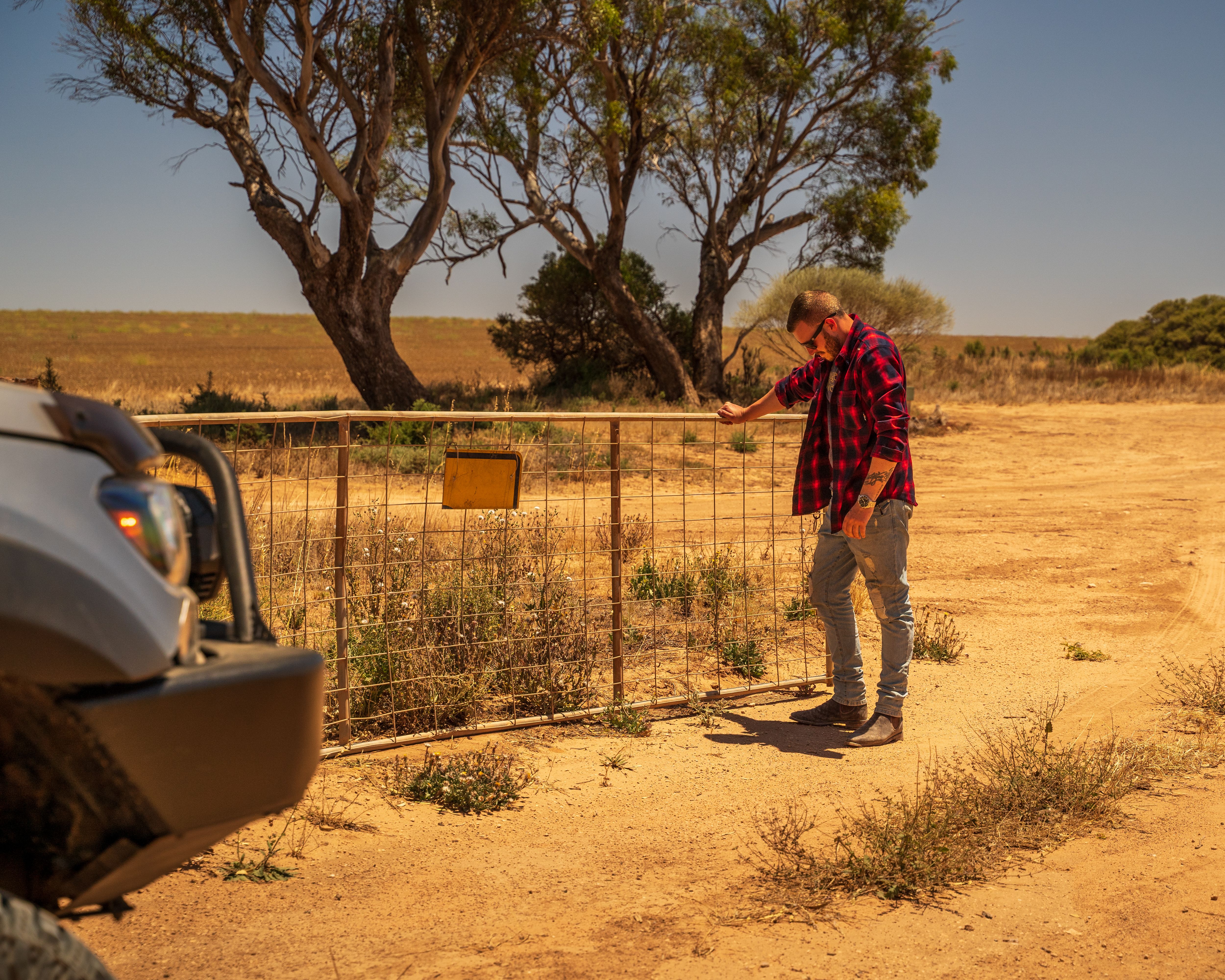 Josh Leonard in the Australian Outback, opening a gate with his 4X4 Ford Ranger