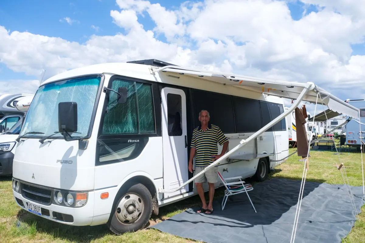 Derek stands under awning of Mitsubishi Fuso Rosa motorhome