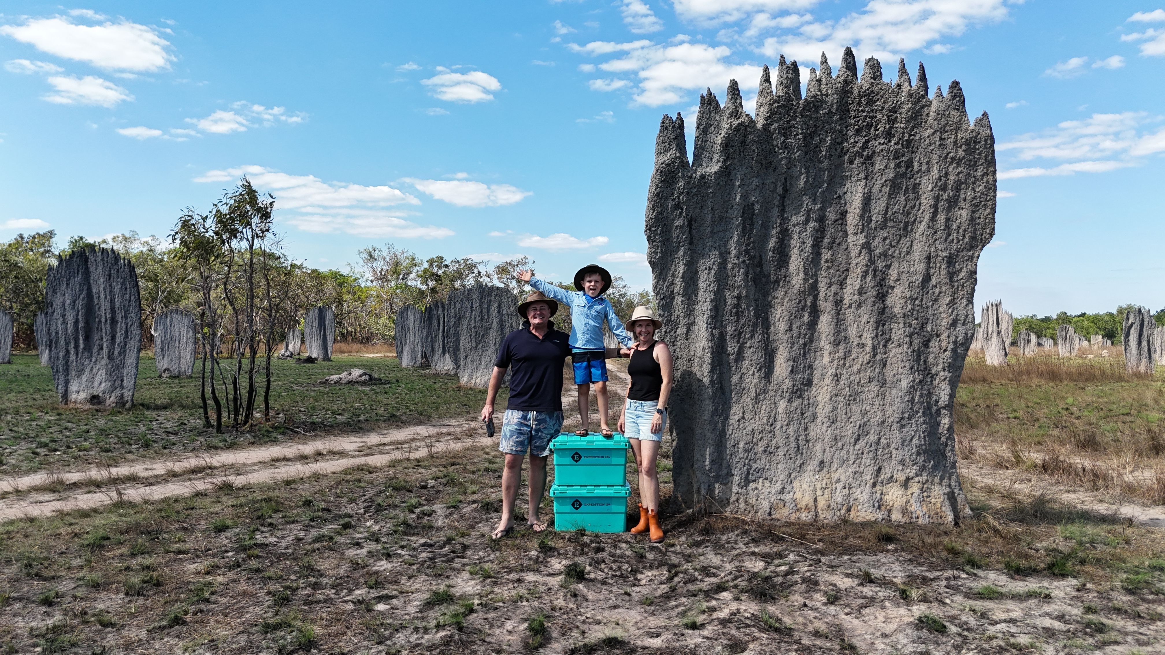 A family posed besides a giant termite mound in Australia's outback
