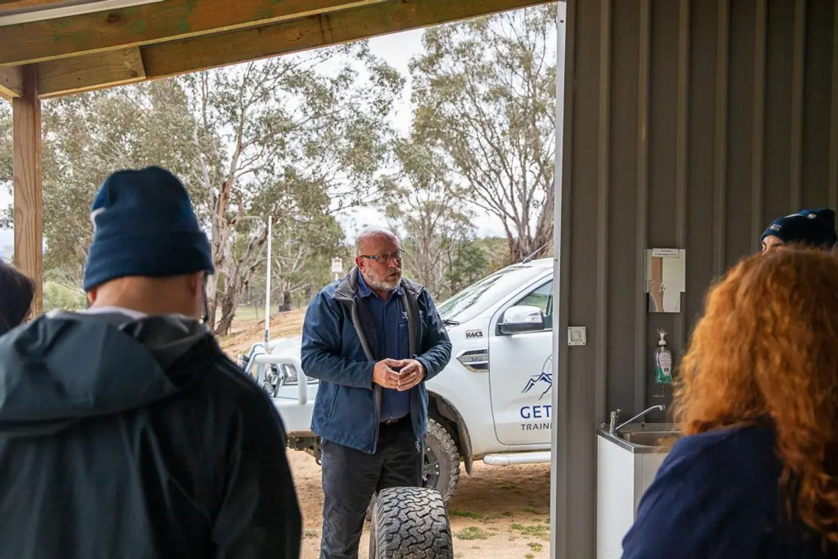 A group of people standing in a room Description automatically generated