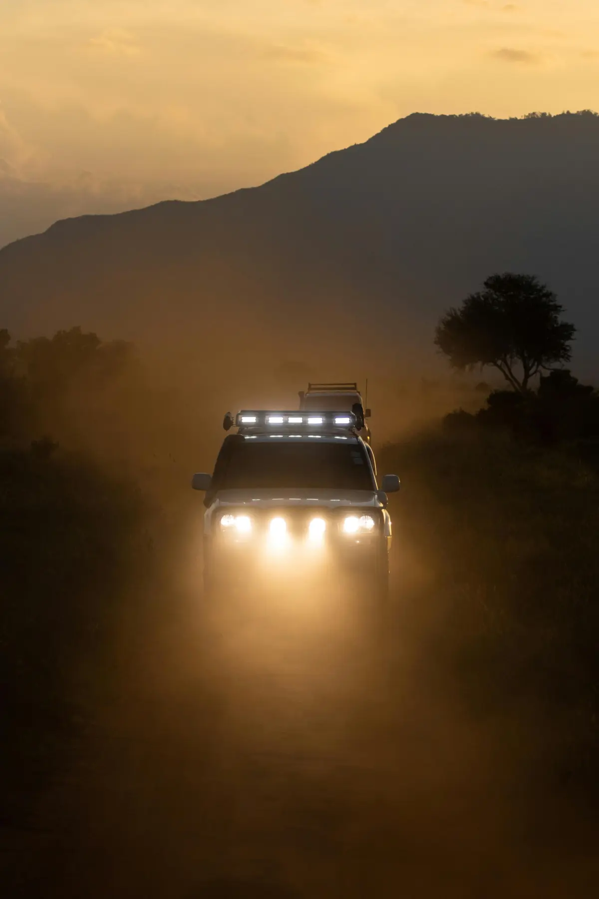 4wd with high beam lights driving through dust at night
