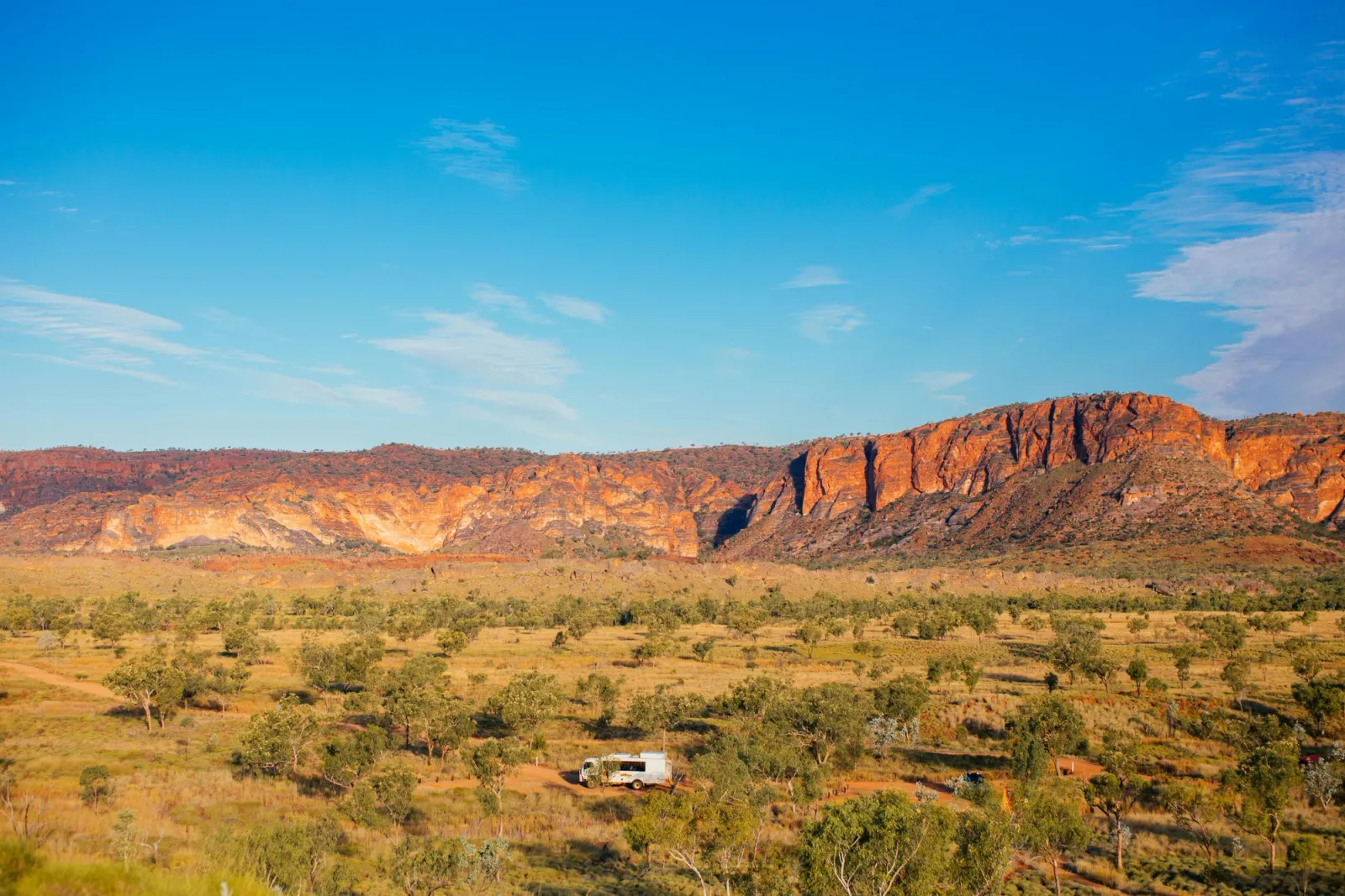 RV in outback Australia in front of mountains with blue sky