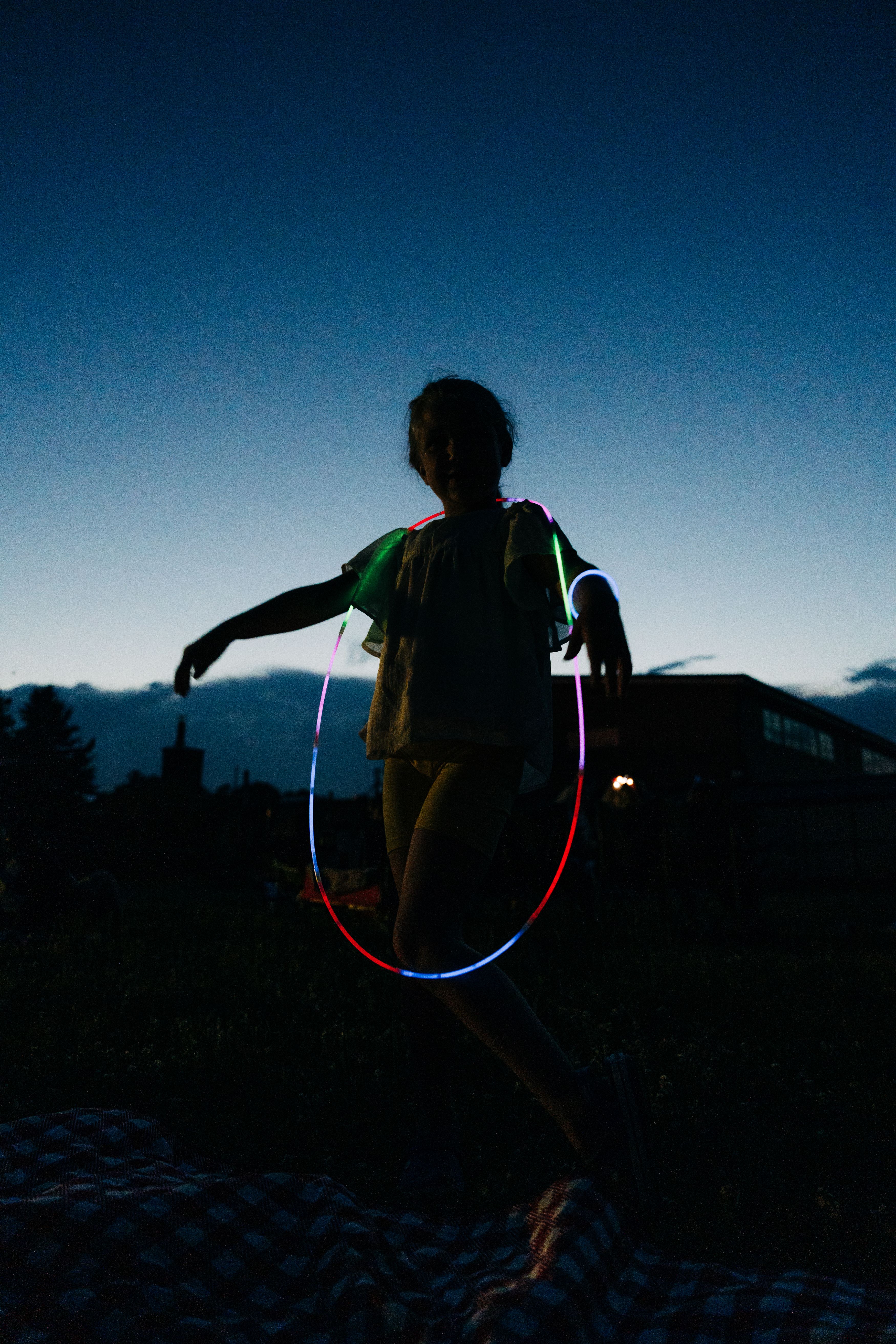 kid in outdoor setting with glowsticks around their neck