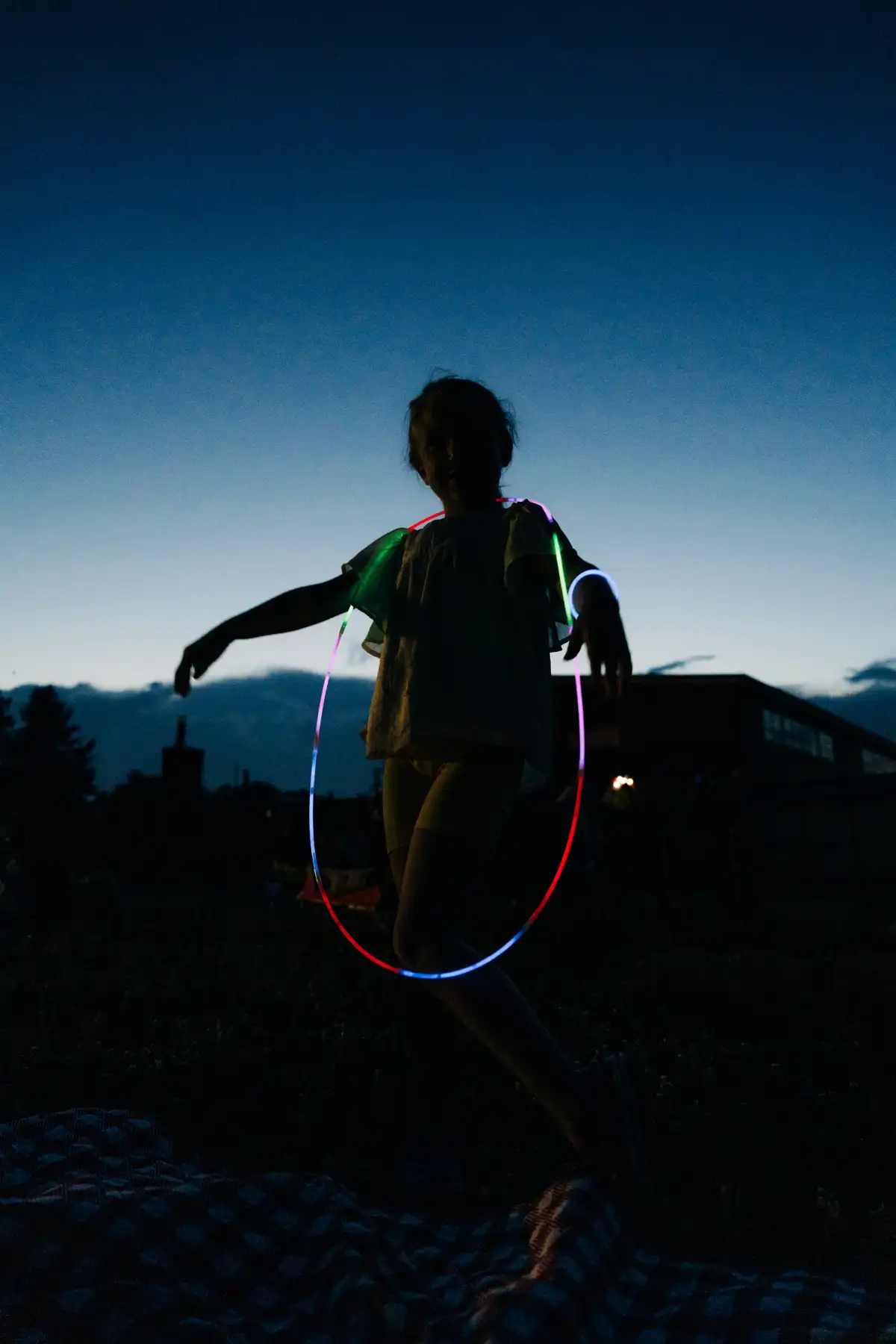 kid in outdoor setting with glowsticks around their neck