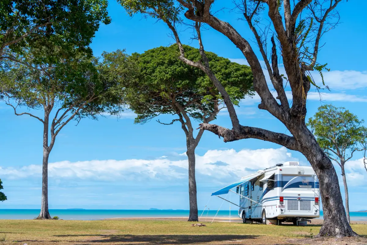 A motorhome in Australia with its awning extended by the beach