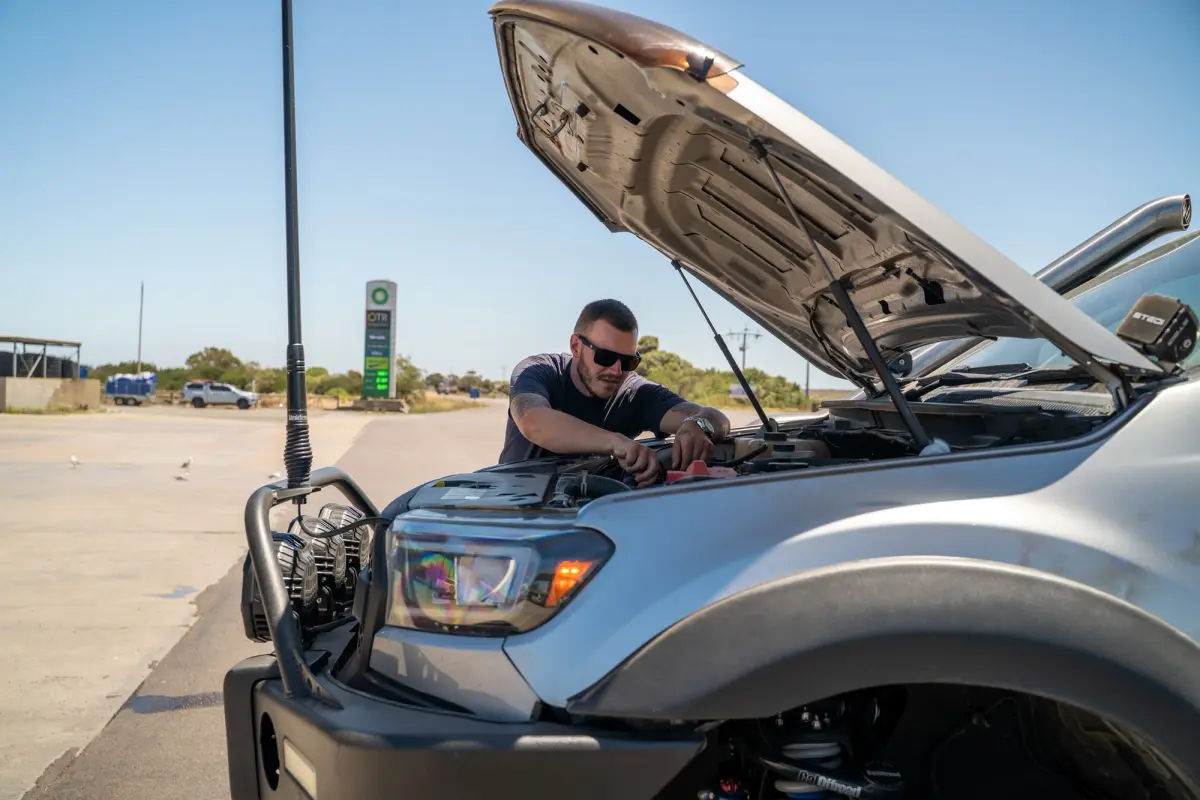 A man inspecting the engine bay of a Ford Ranger 4X4