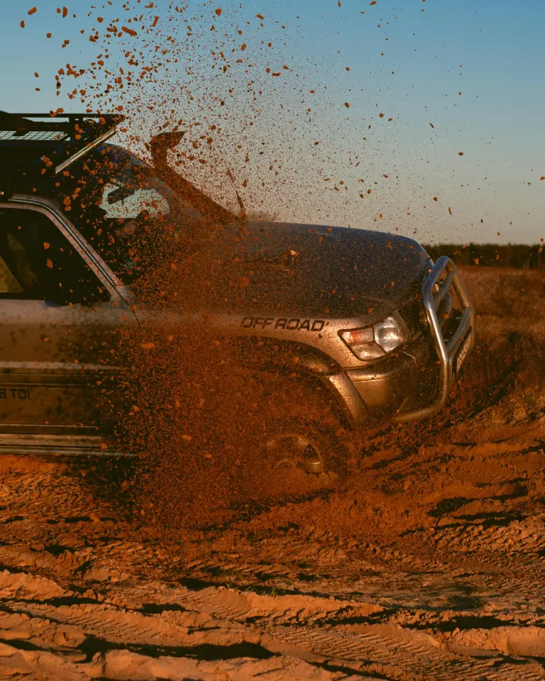 nissan patrol 4x4 driving through sand and kicking it up