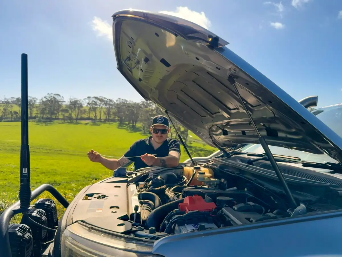 Josh Leonard inspecting the engine of his 4X4 Ford Ranger