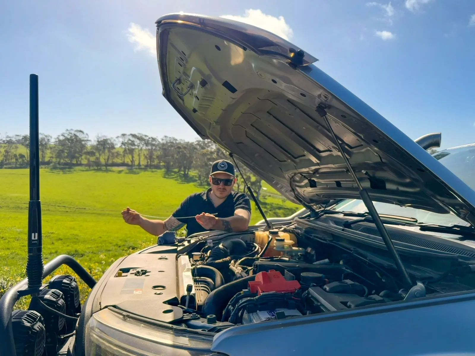 man checking under the bonnet of a 4wd
