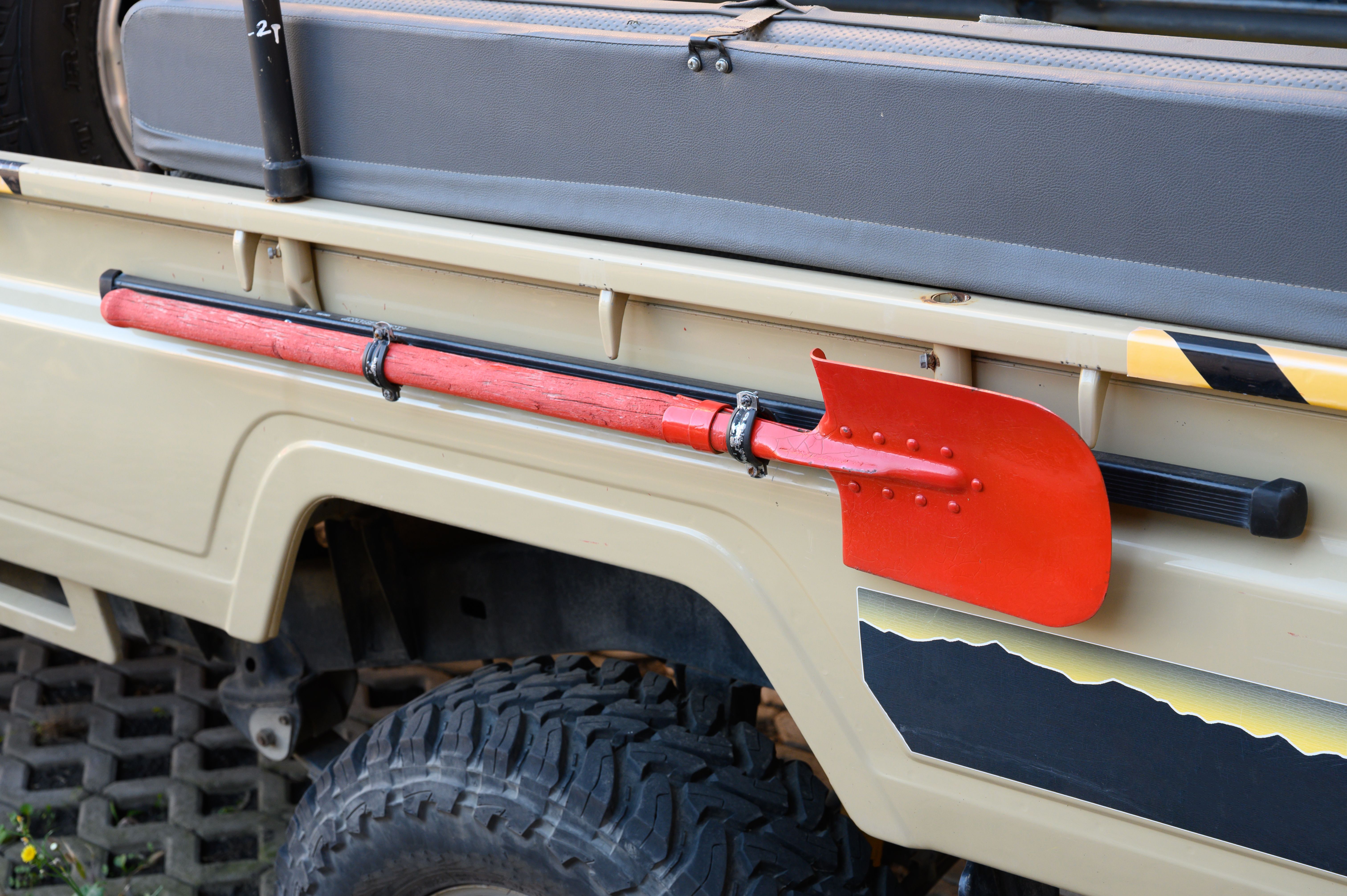 red long handle shovel mounted to a 4x4