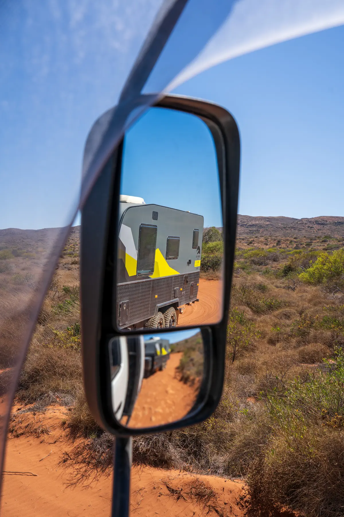 A caravan pictured from a rear view mirror out a Ford Ranger 4X4