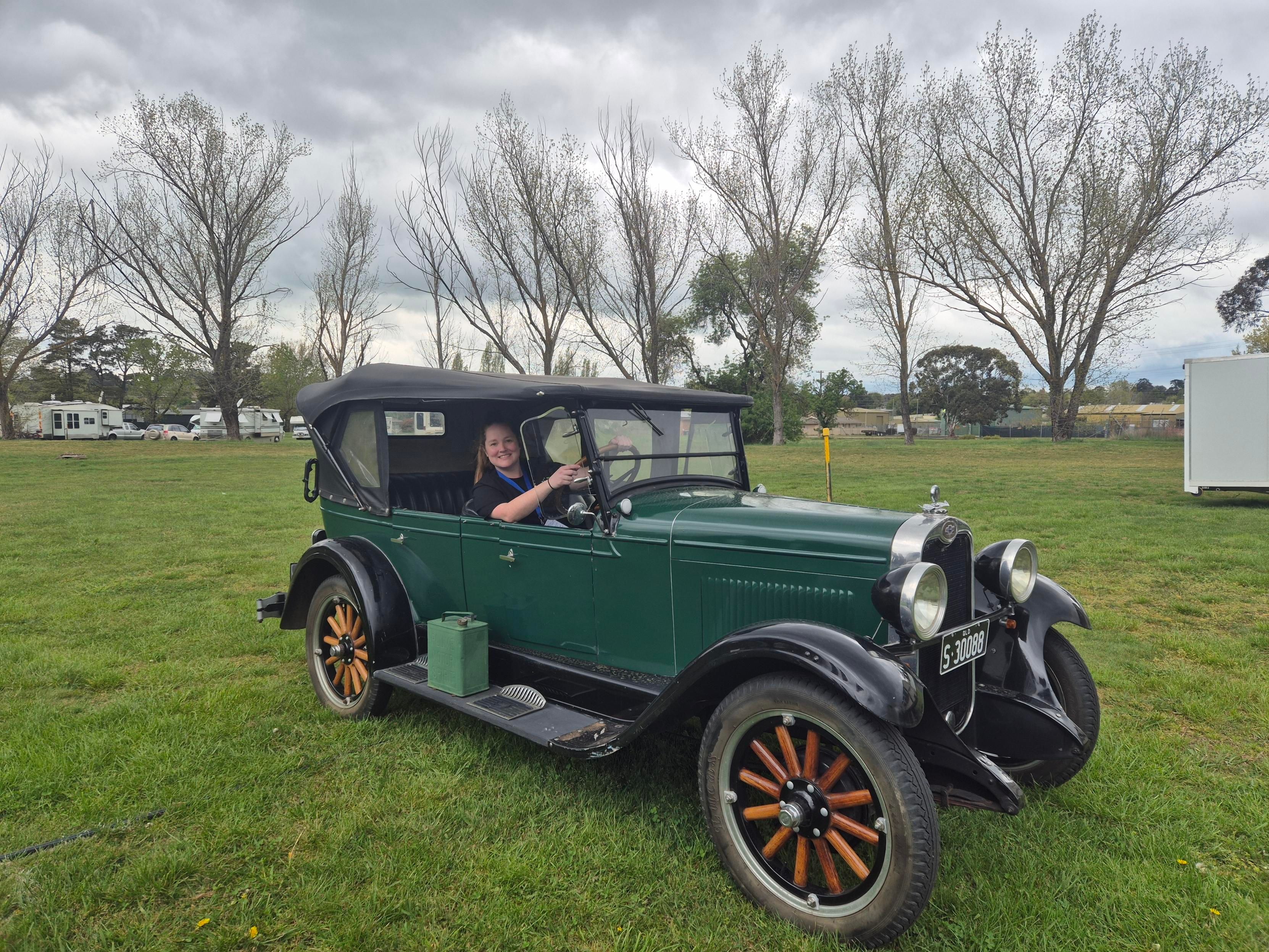woman sitting in a green vintage car