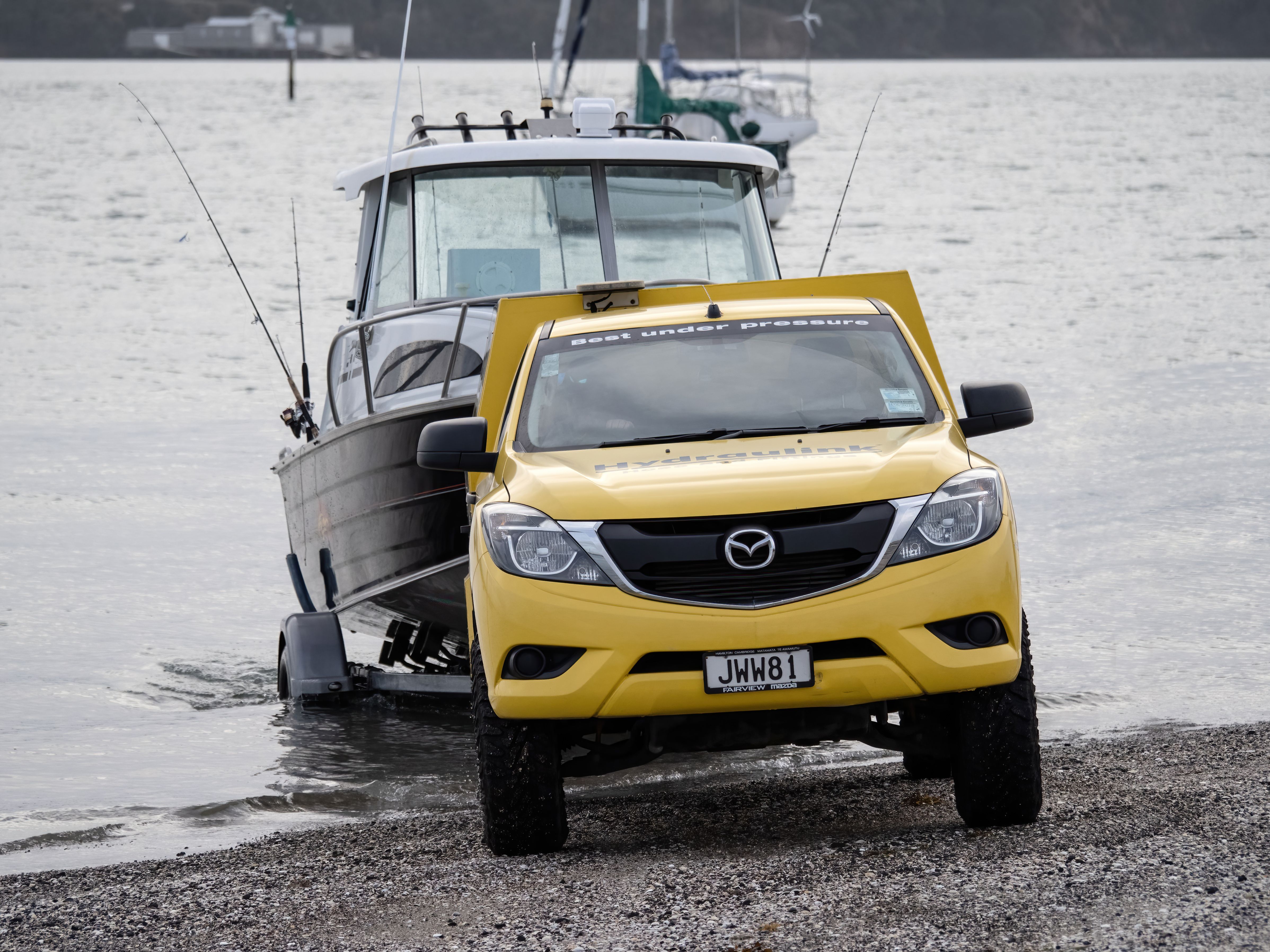 yellow 4X4 towing boat out of water