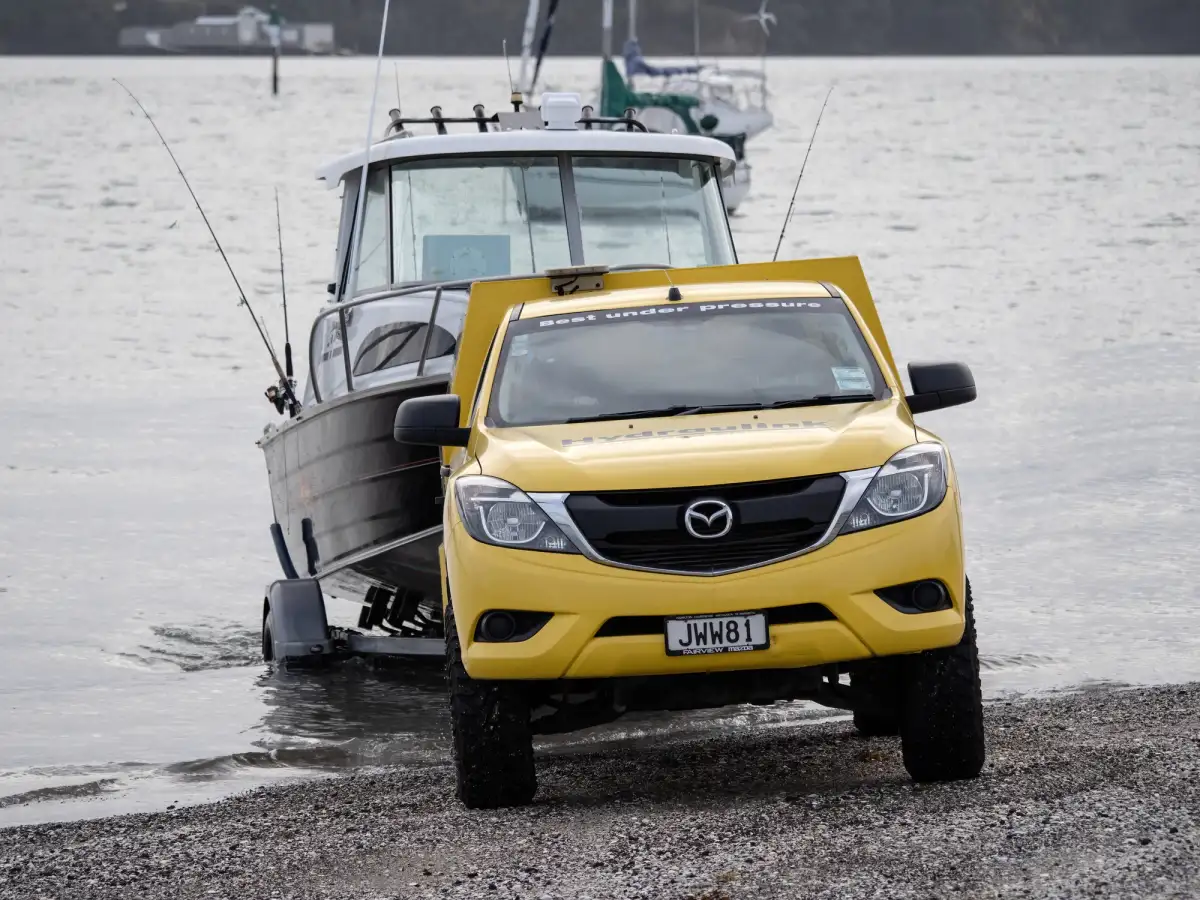 yellow 4X4 towing boat out of water