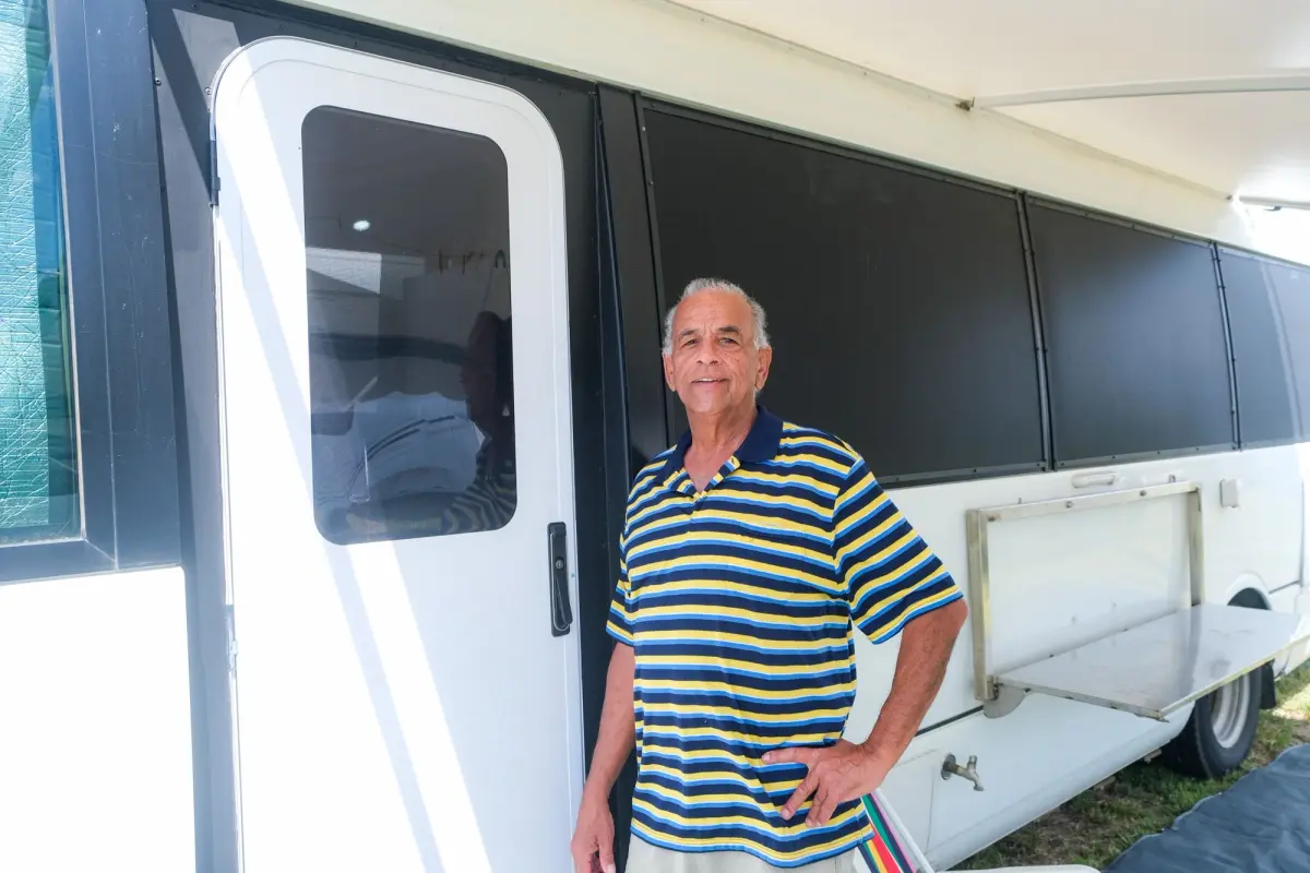 Derek stands next to door of Mitsubishi Fuso Rosa motorhome