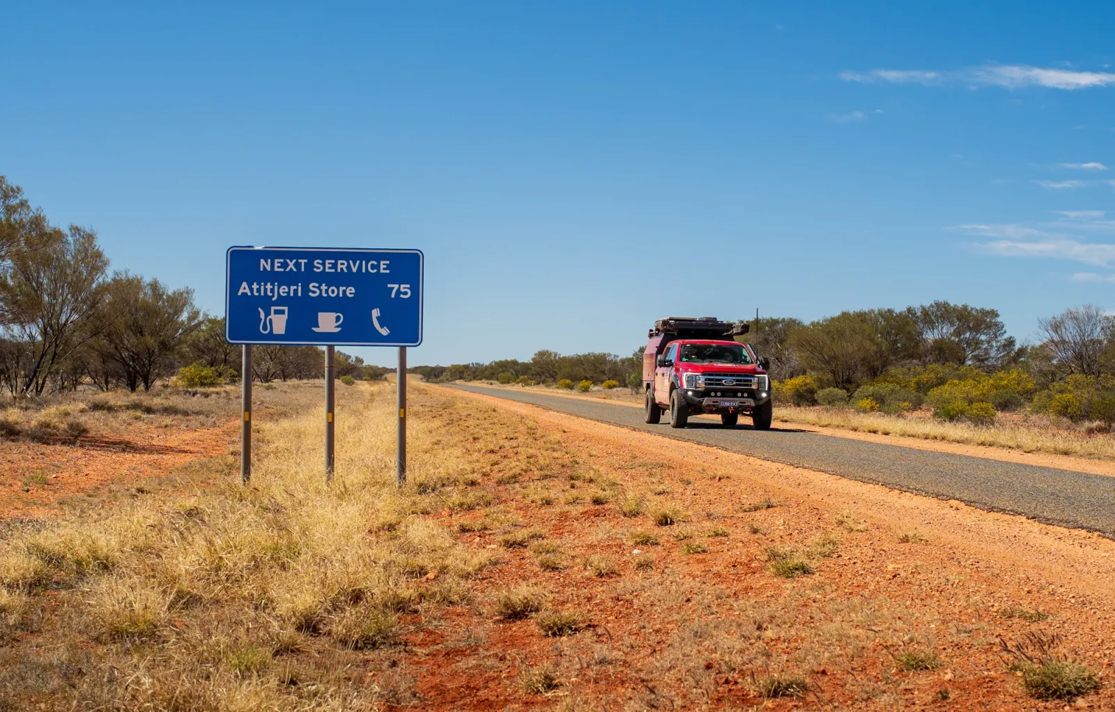 4wd on a remote road with a blue road sign