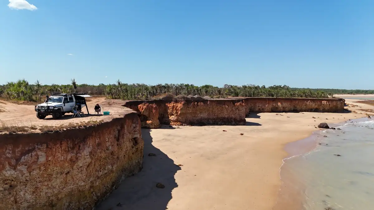 A 4X4 set up for camp on a cliff overlooking a beach