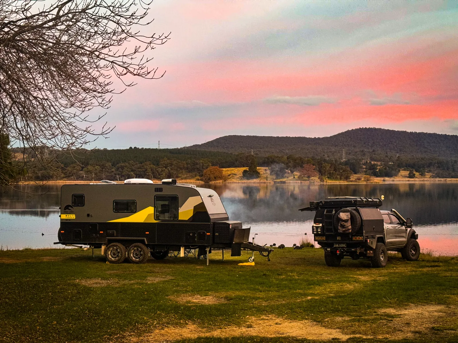 4x4 and caravan camping by a lake at sunset