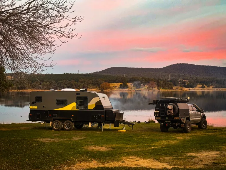 4x4 and caravan camping by a lake at sunset