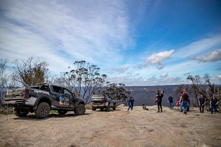 A group of people walking down a dirt road Description automatically generated