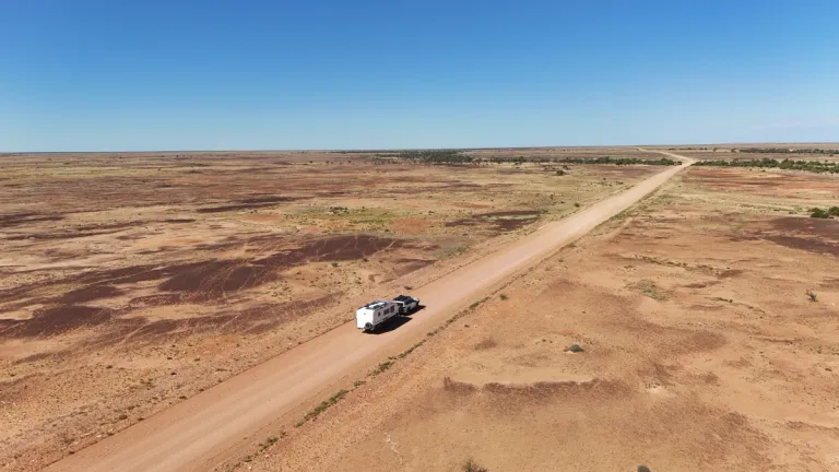 4x4 towing caravan through outback aerial shot