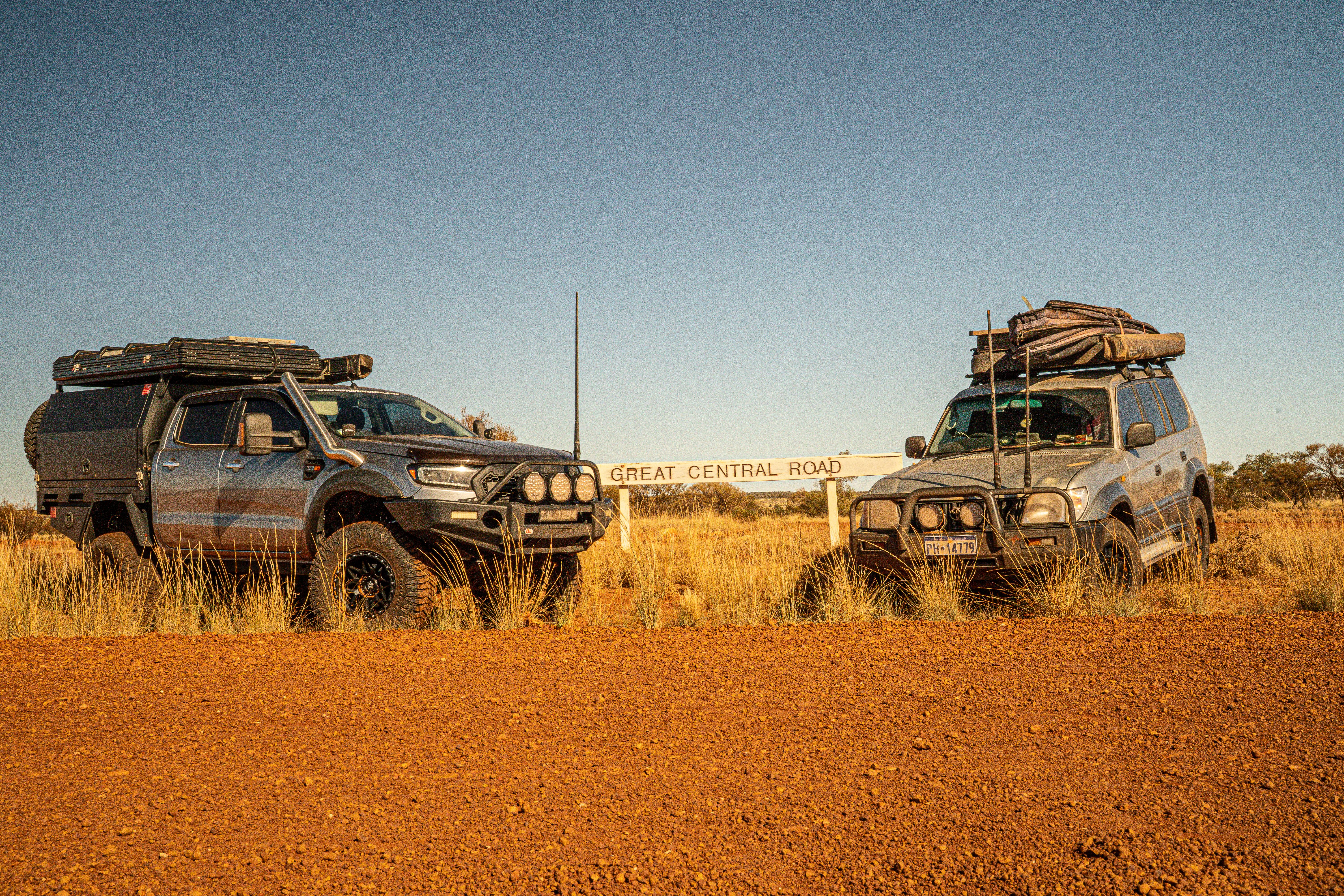 two 4WDs parked in front of a Great Central Road sign