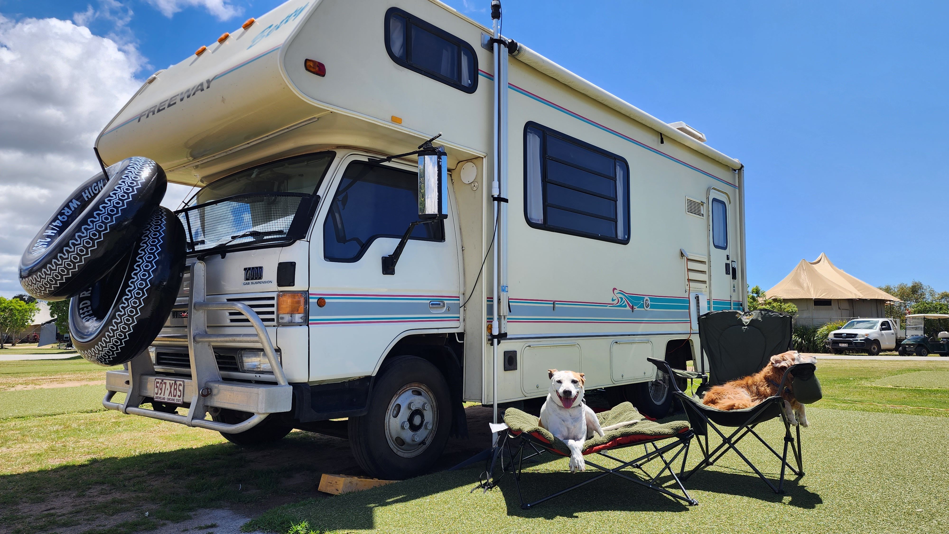 Motorhome with 2 dogs in camp chairs